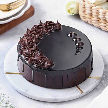 A chocolate truffle cake covered in ganache